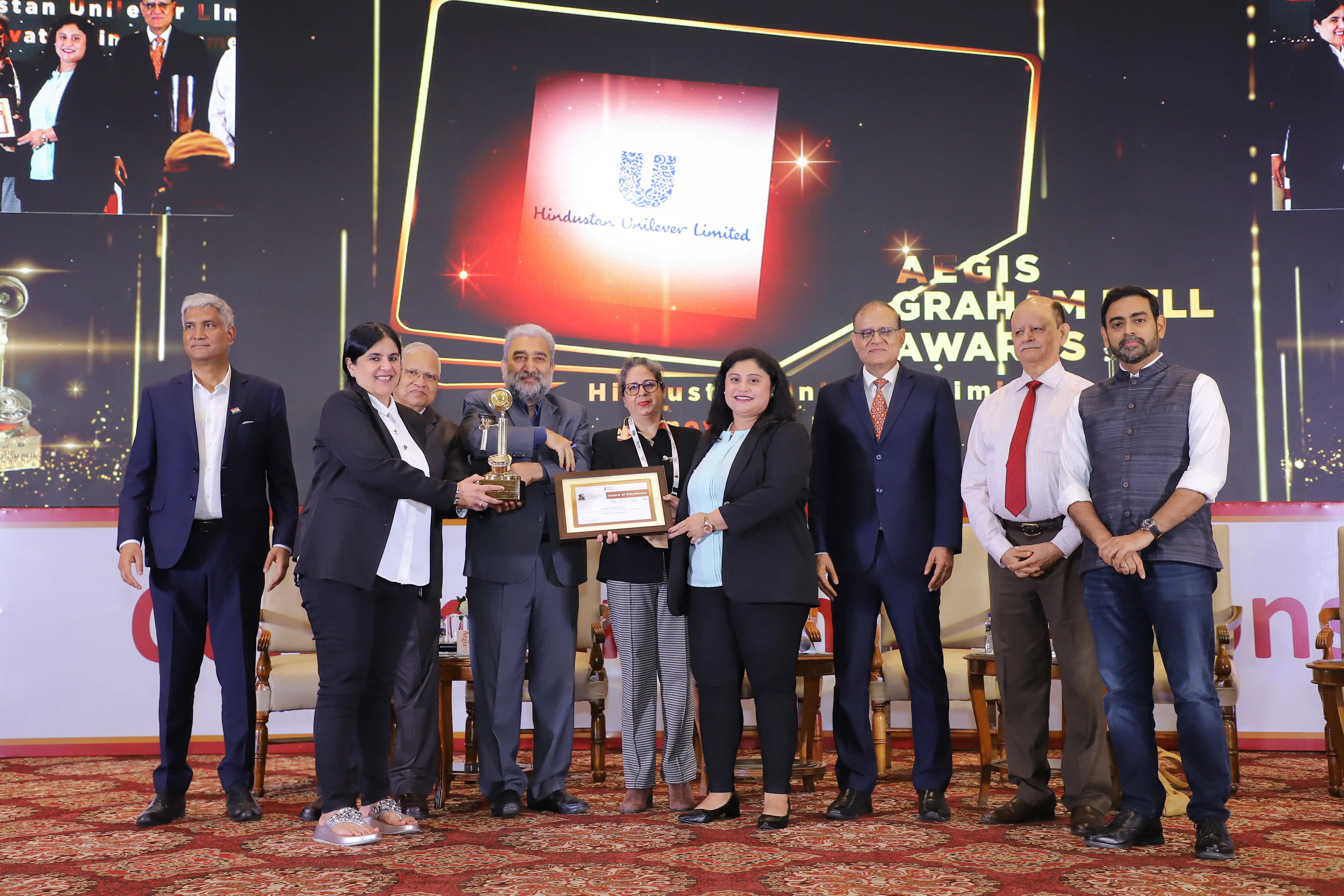 Group celebrating with the Aegis Graham Bell Award trophy.